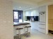 白色調延伸至廚房，以開放式廚房讓整體空間更加寬敞。